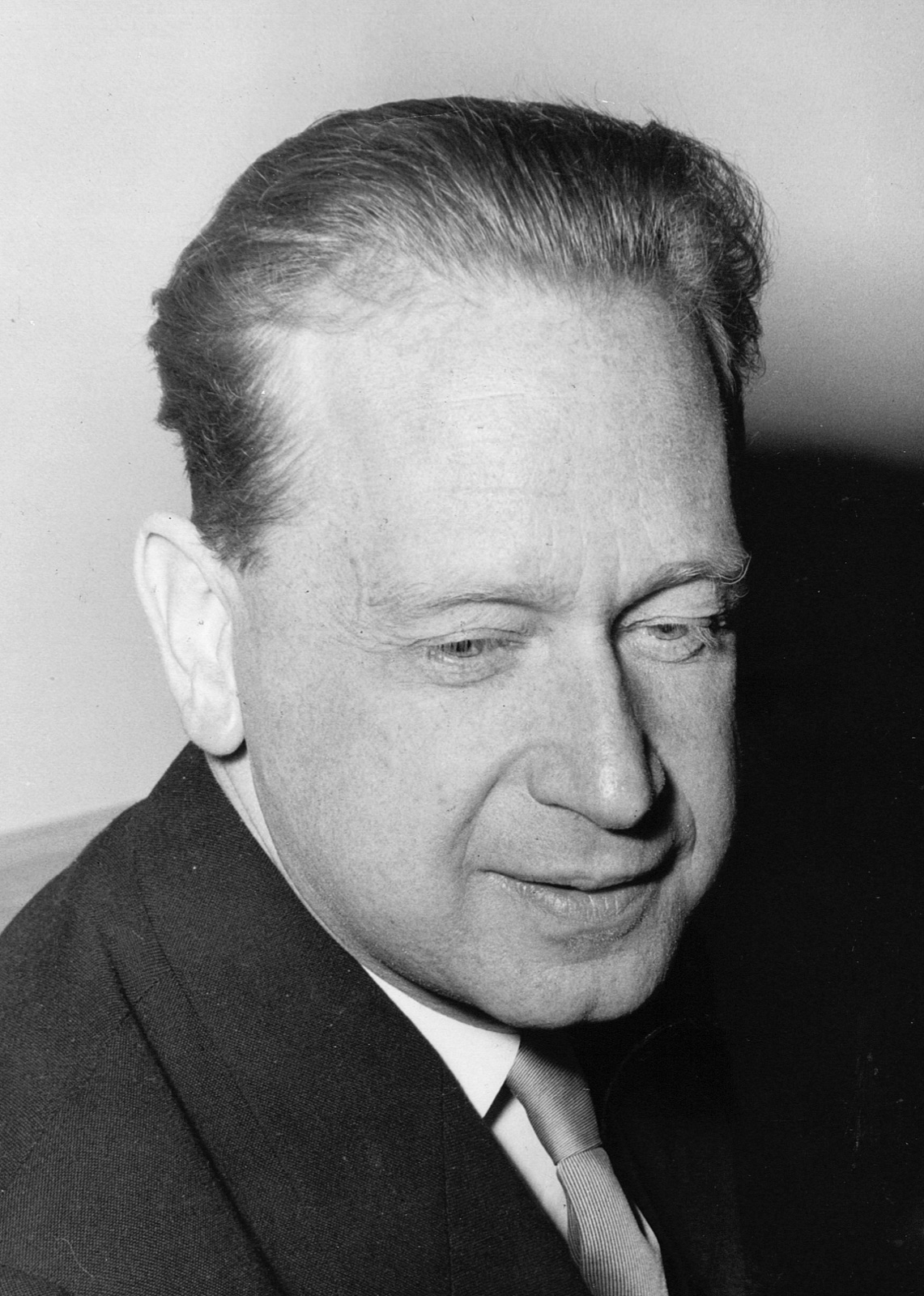 Black-and-white 1961 photograph of Dag Hammarskjöld in a dark suit, eyes lowered.