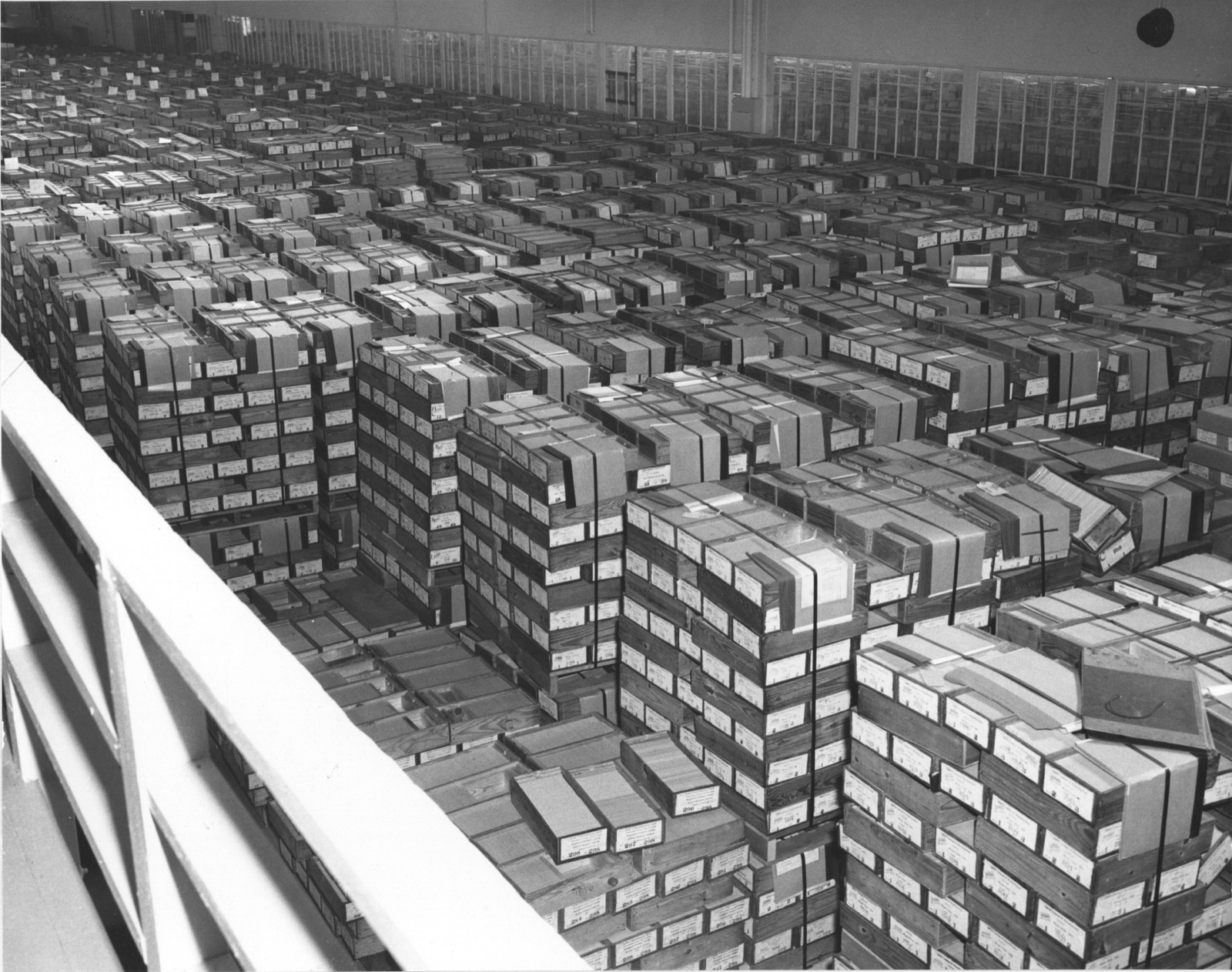 A National Archives photograph looking out over a large hall filled with row upon row of stacked boxes of IBM punched cards.