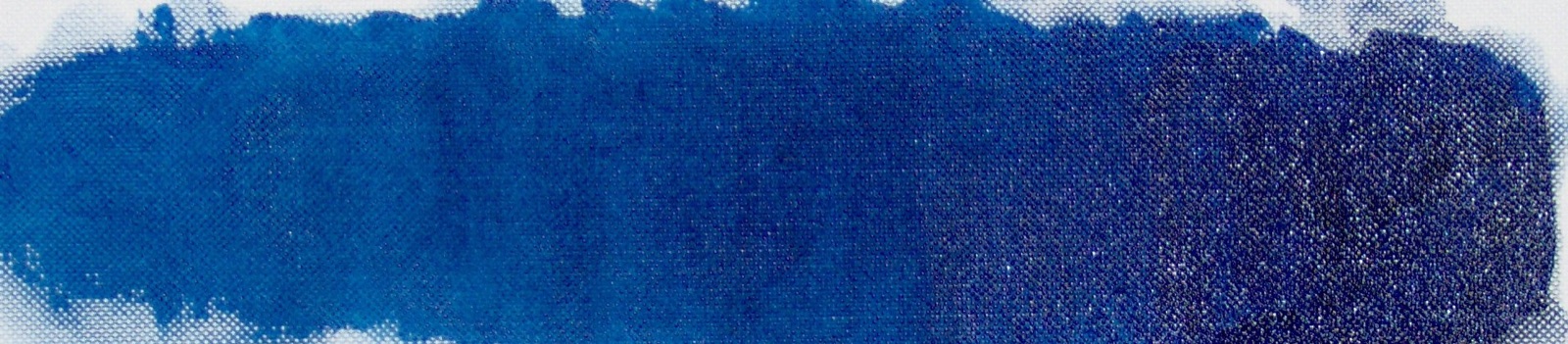 A wide painted swatch of Prussian blue pigment on white paper.